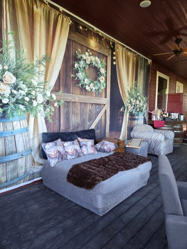 Styled for Comfort Cozy seating area with floral decorations and rustic wooden backdrop.