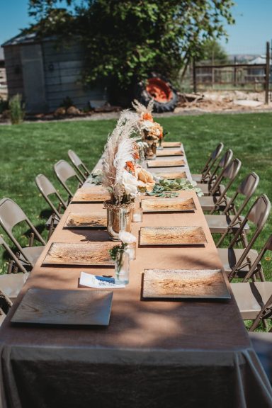 Alfresco Celebration Outdoor dining table set with floral centerpieces and place settings.