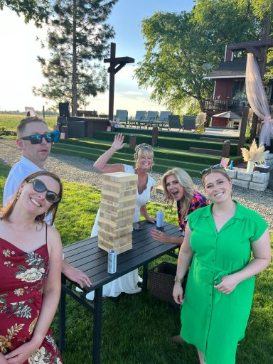 Love, Laughter, and Lawn Games Group of five people enjoying a sunny outdoor gathering with a Jenga tower.